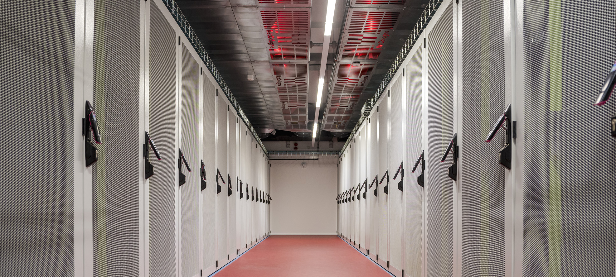 Rechenzentrum_Bildergalerie_Nachhaltiges_DC_Schränke | NetCologne ITS Blick in den Gang eines Rechenzentrums mit Serverschränken an der rechten und der linken Wand