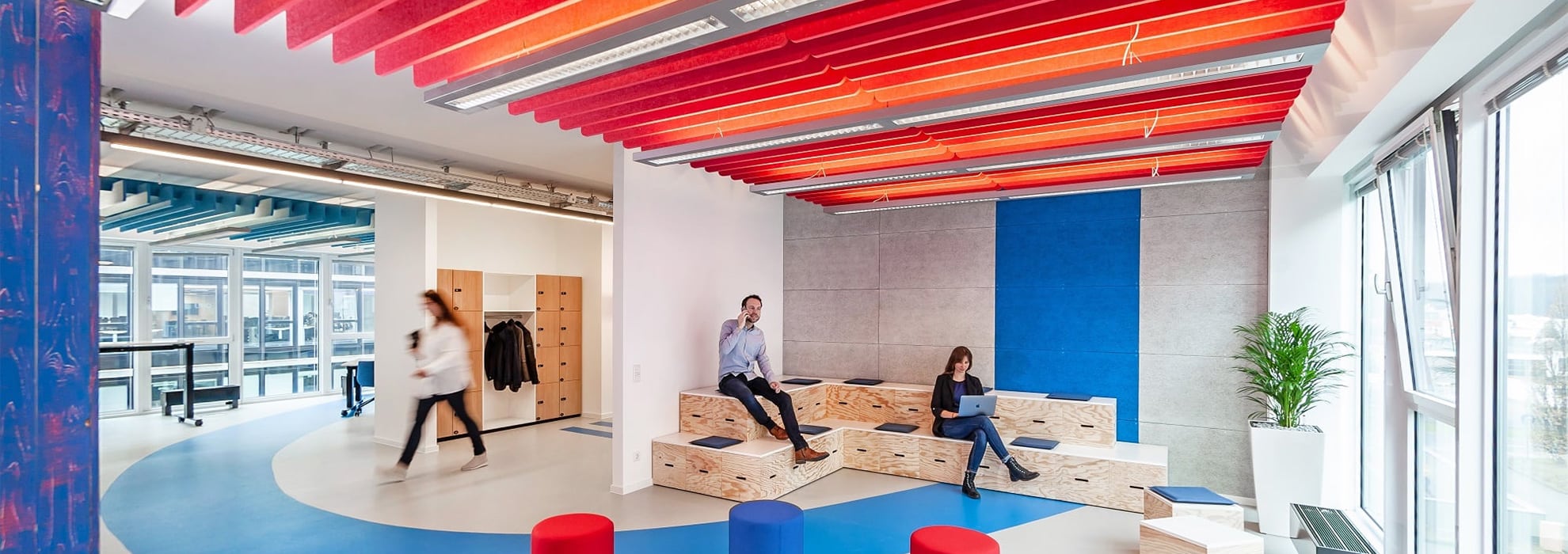 Menschen bewegen sich in einer offenen und modernene Bürolandschaft